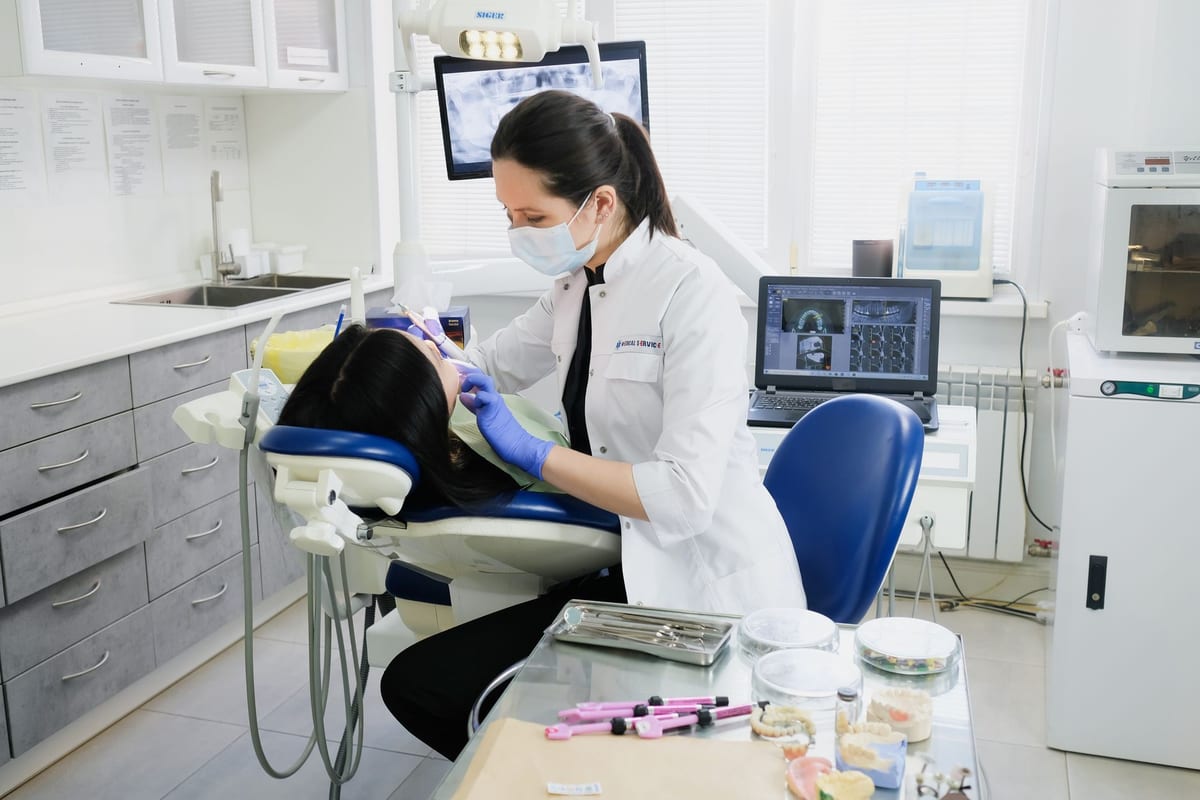 A clinician treating a patient in a dental chair